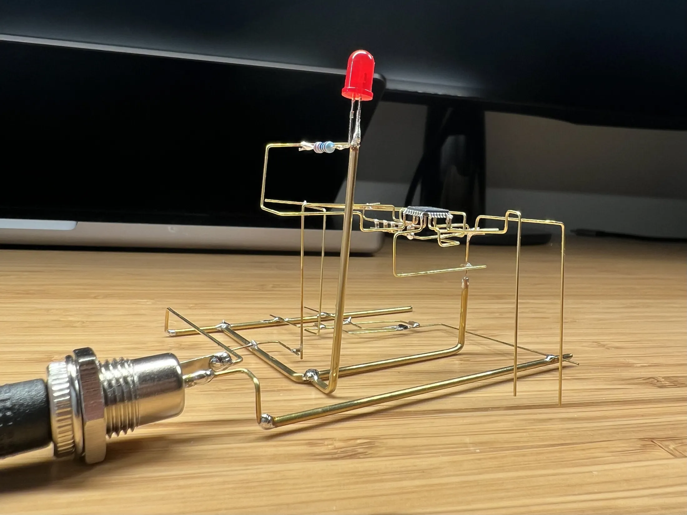 The freeform clock: brass rods soldered into an open frame holding the STM32, a red LED and a DC jack