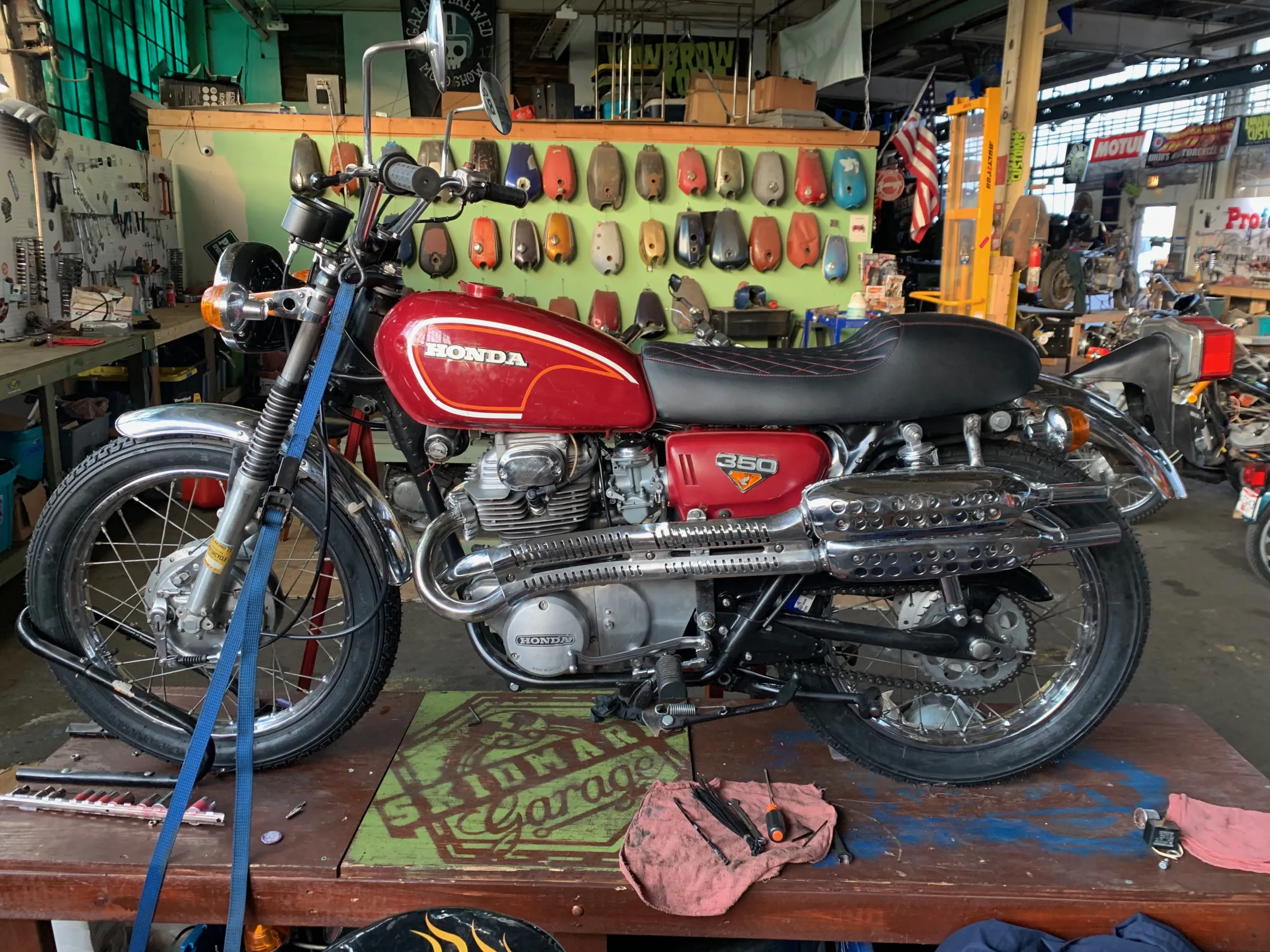 The red CL350 nearly complete on a motorcycle lift
