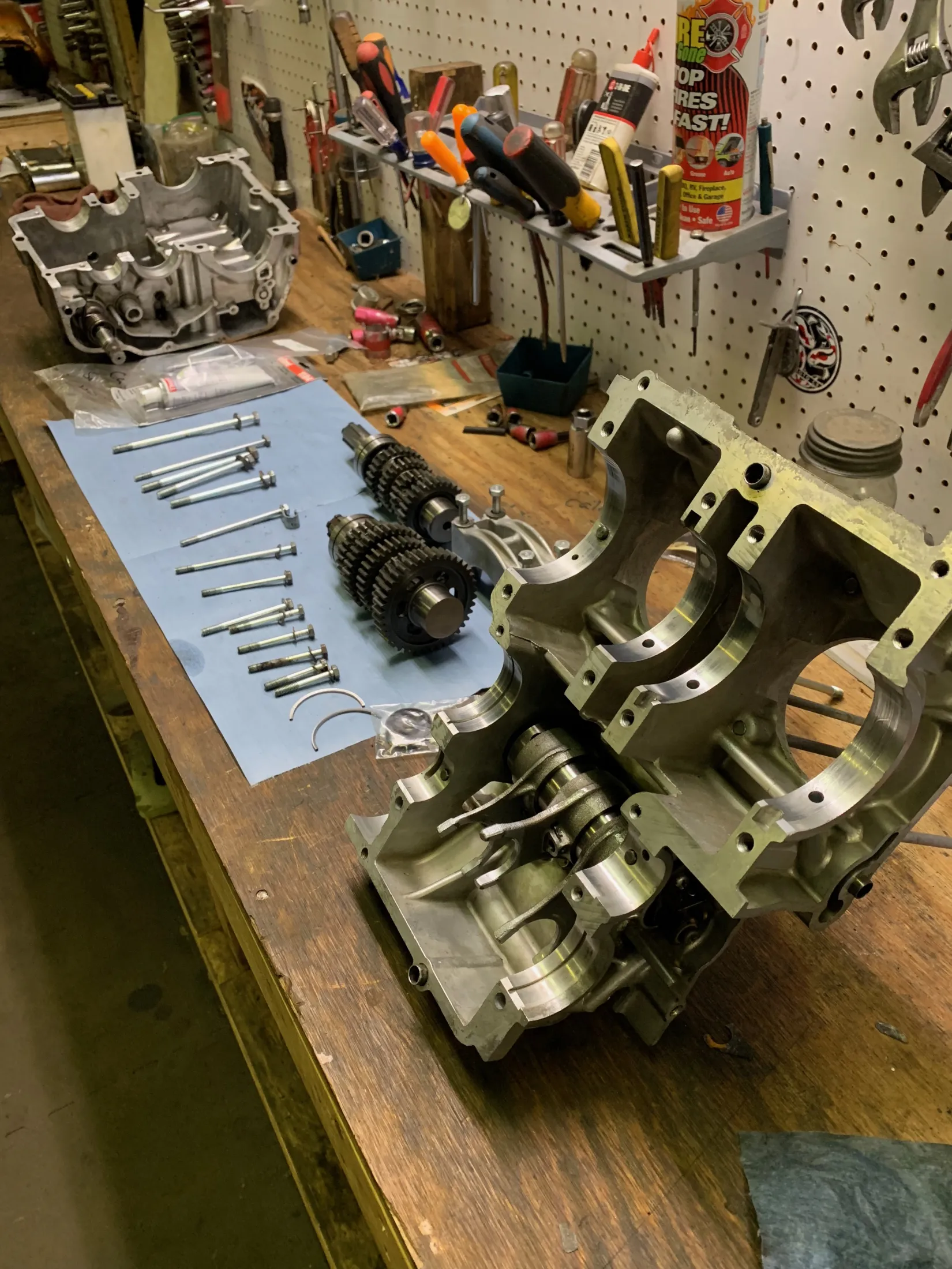 Engine case with the transmission gears and bolts laid out beside it